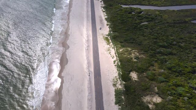 Parallel bands of surf, sand, and asphalt form an aerial Outer Banks composition.  North Carolina

