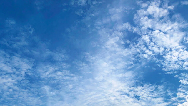 Vibrant blue sky covered with wispy white cirrocumulus clouds background