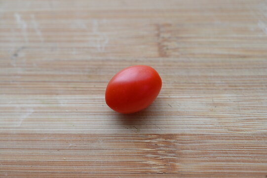 木のまな板に置いた無農薬の赤いミニトマト 採れたての夏野菜
