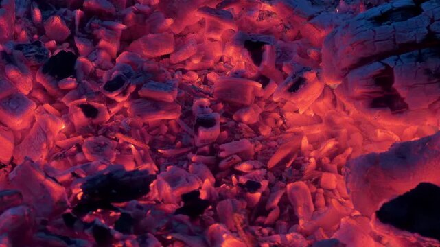 Red hot coals glowing and flickering in a wood fire in 4K footage