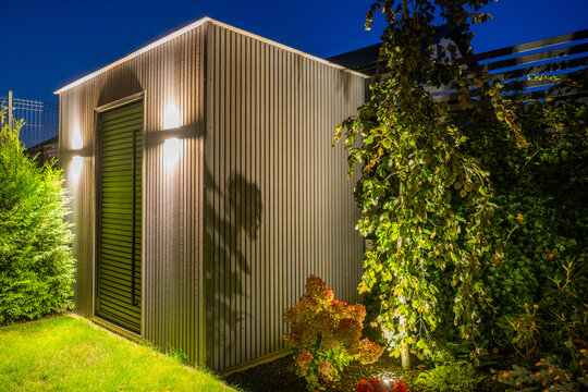 Modern garden shed illuminated by exterior lights at night