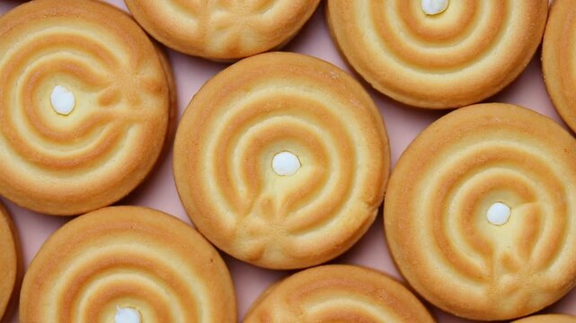 Cream filled sandwich cookies arranged in rows rotating. Top view shot