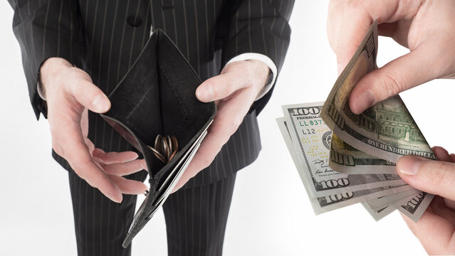 Personal finance, businessman shows an almost empty wallet while another person holds US dollar banknotes, symbolizing debt, poverty and financial loss.