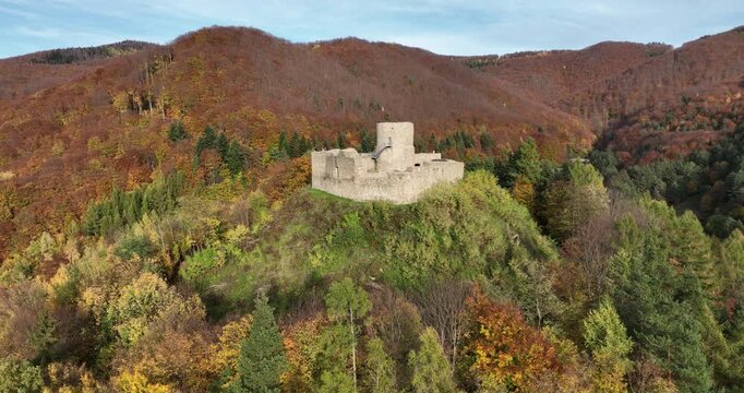 Aerial approach to Rytro Castle ruins above autumn forest