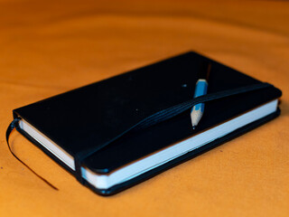 Small drawing pad on an orange surface with copy space in the top left corner.  © Tuccera