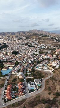 Vista a&eacute;rea del distrito de Puerto de la Torre en M&aacute;laga, Espa&ntilde;a. Plano cinematogr&aacute;fico con dron de la zona residencial, casas adosadas y expansi&oacute;n urbana en las afueras de la ciudad.