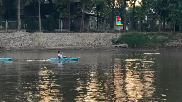 Person kayaking on Ping river at sunset in Chiang Mai