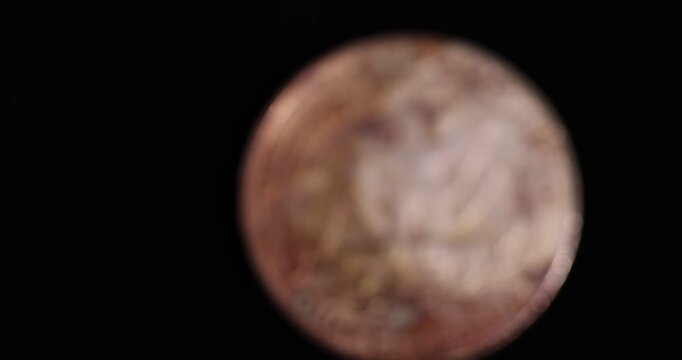   rust  quarter-dollar coin on a black velvet cloth, one damaged 25-cent coin covered with yellow rust and plaque, close up
