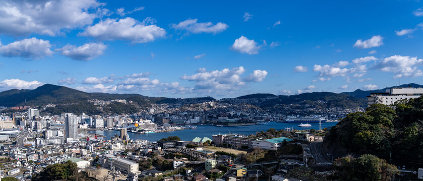 Expansive Nagasaki cityscape and Nagasaki Port framed by clear blue sky from Mount Inasa.