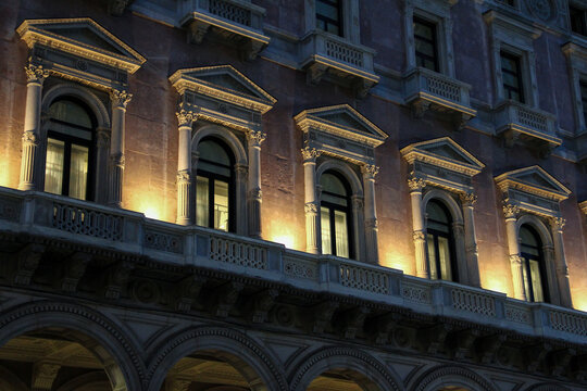 Illuminated Facade Windows of Palazzo Carminati at Night in Piazza del Duomo, Milan, Italy