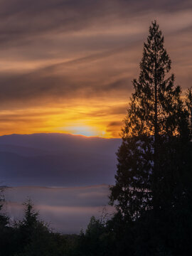 Colorful Sunrise and Morning Fog dreamy over the Mountains near Burke Mountain, Coquitlam, British Columbia, Canada