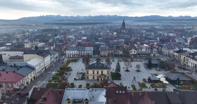 Aerial reveal of Nowy Targ Market Square and the Tatra Mountains