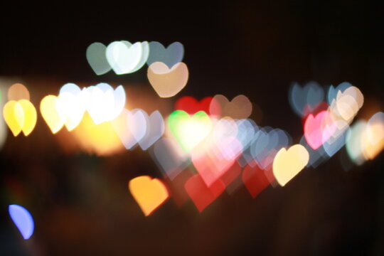 Vibrant heart shaped bokeh lights glowing in the dark night