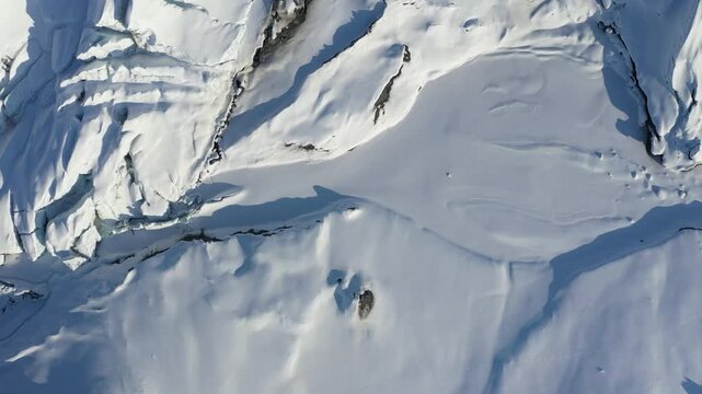 Abstract High-Angle Flyover of Snow Texture and Icy Crevasses on Glacier Field