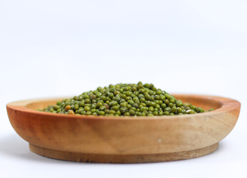 Green mung beans on wooden plate isolated on white