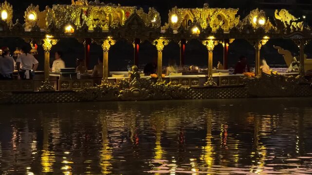 Thai pavilion reflecting on river at night in Chiang Mai