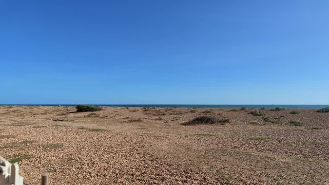 Hayling Island Hampshire England UK. 05.09.2026. Video. A wide landscape shot capturing a vast expanse of pebbles and stones along the coastline with the calm ocean 