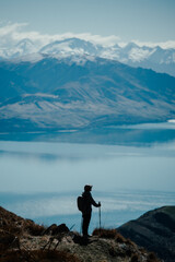 Obraz premium Hiker Descending Mountain Trail with Alpine Scenery in Background