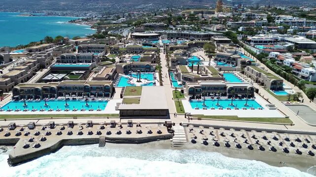 Beachfront luxury holiday properties, Nana Royal Premium resort and Spa surrounding sea waters, Crete, establishing drone shot