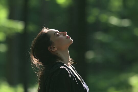 Woman's profile with head tilted back in nature