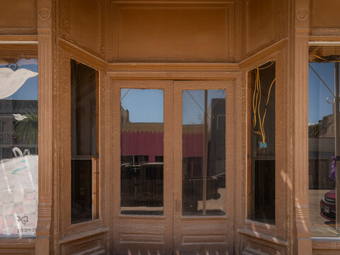Exterior view of a vintage historic storefront with wooden frame architecture and double doors undergoing renovation in a small town