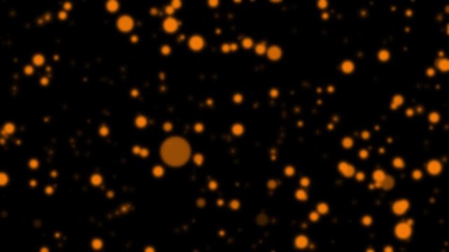 Orange glowing particles float on black background, abstract motion background with bokeh effect, cinematic footage of glittering lights in darkness, festive celebration atmosphere.