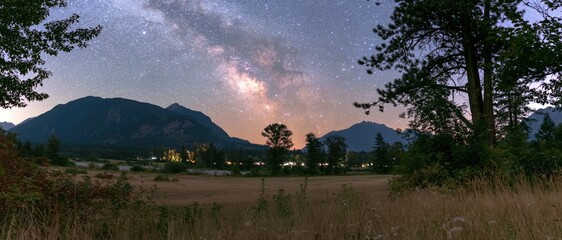Milky Way Arching Over Mountain Range and Rural Field © arrin