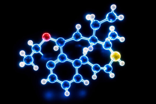 A luminous molecular model of colored atoms and bonds glows against a pure black background. Organic chemistry and scientific innovation