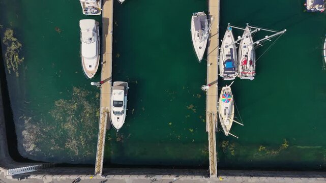 St Peter Port Harbour Guernsey Channel Islands .Overhead, slow,panning, detailed drone footage of boats moored in Victoria Marina alongside Albert Pier car park in bright sun