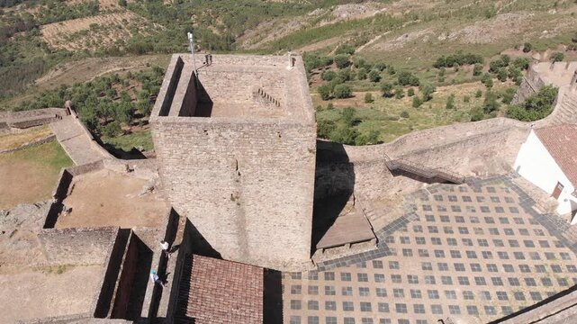 Aerial drone flight around the main tower of Marv&atilde;o Castle, a medieval fortress overlooking the Alentejo landscape, Portugal.