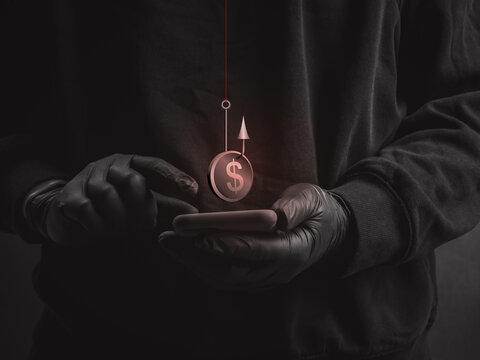 Anonymous scammer with black gloves uses smartphone beneath money hook symbol. Mobile phishing, financial scams, cybercrime, digital deception and online theft targeting personal funds concept.