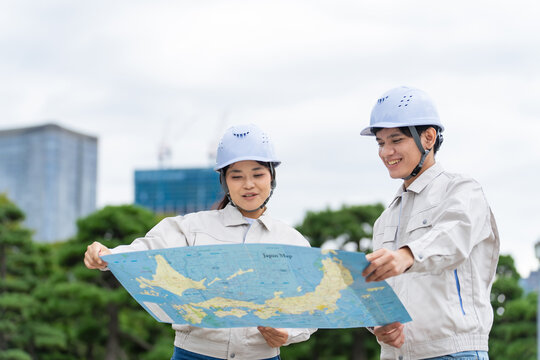 日本地図を見るアジア人労働者。建設、工事、技能実習生、外国人、建築、仕事、東南アジア、作業員、働く