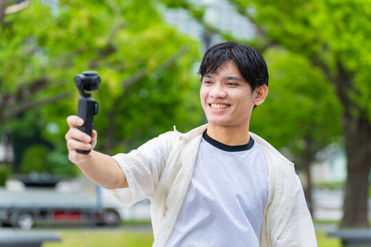 Asian tourists taking selfies with action cameras. Video, live streaming, inbound tourism, foreigners, social media, popular