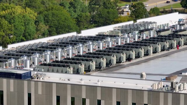 Aerial close up view of a large industrial rooftop covered with rows of HVAC cooling units and ventilation systems	
