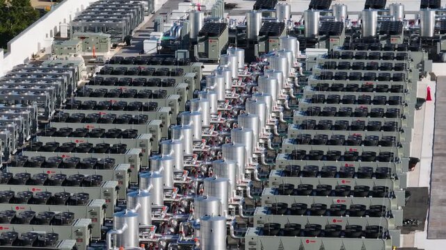 Aerial close up view of a large industrial rooftop covered with rows of HVAC cooling units and ventilation systems	
