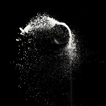 Fluffy White snow splash flying or throwing in mid air. Snowfall on Black background isolated. Snow dust element falling over dark night