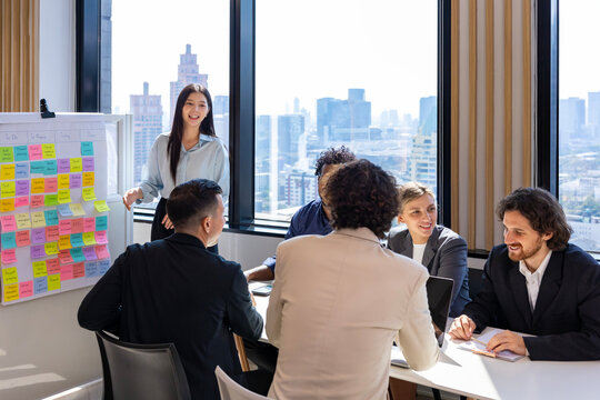 Woman manager is presenting new project to the team while having question from panel in the executive meeting for next year plan with market share increase for global business and investment