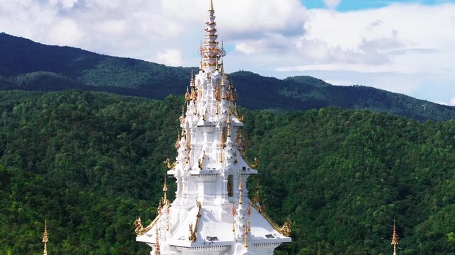 Aerial close view of an ornate white spire with gold details