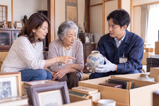 遺品整理で残す品物を家族に確認するスタッフ
