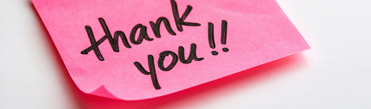 A Note of Gratitude: A vibrant pink sticky note bearing a handwritten Thank you!! message, presented in a close-up, offers a simple yet heartfelt expression of appreciation.