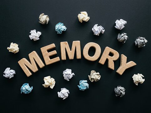 Wooden letters spelling MEMORY surrounded by crumpled paper balls suitable for psychology media symbolizing forgotten thoughts and cognitive function