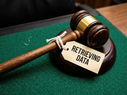 Wooden gavel with a tag reading retrieving data suitable for cyber law content symbolizing legal authority over digital evidence and compliance