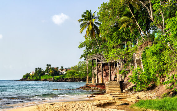 Scenic tropical la Toc Beach with crumbling stairs, palm trees, cliffs, and ocean near Castries in Saint Lucia.