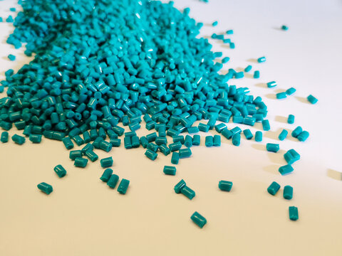 plastic masterbatch, green masterbatch granules as virgin polymer resin pigment, poured into white background media, suitable for industrial plastic company profile product catalog design
