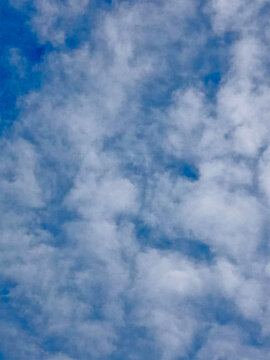 Fluffy cumulus clouds fill a vibrant blue sky creating a scenic backdrop