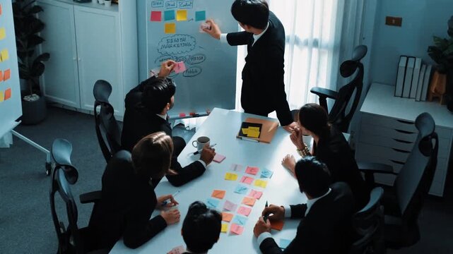 Top view business man put sticky notes on whiteboard with mind map and colorful sticky notes at meeting while business people brainstorm marketing idea. Manager choose marketing idea. Directorate.