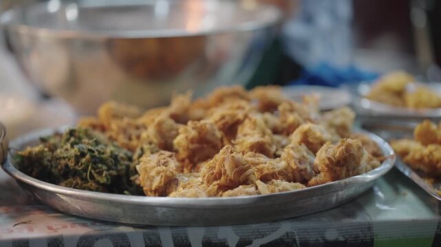 Golden deep fried fritters piled on a tray at a Thai night market