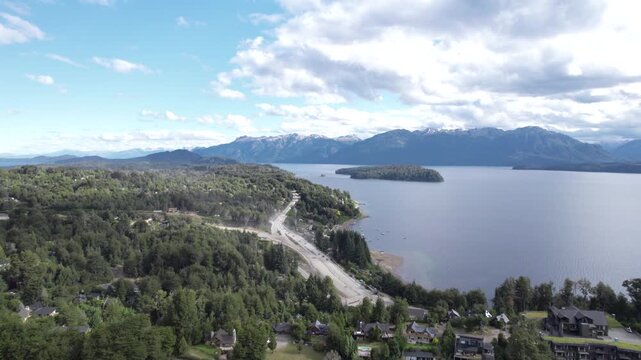 4K drone aerial view of Lake Nahuel Huapi in Patagonia, Argentina. Vast blue waters surrounded by lush forests and dramatic Andean mountains create a spectacular natural landscape.