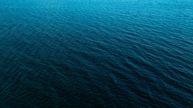 Top view of deep blue sea water surface with small ripples, aerial drone shot of turquoise ocean texture at island , abstract nature background