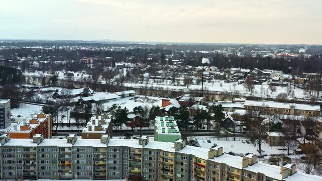 Elevated perspective of a city district with Soviet-era apartment blocks during a winter snowfall